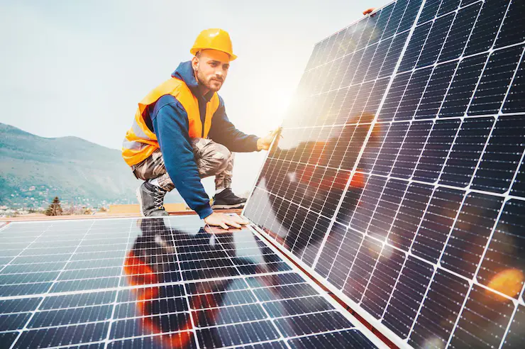 arbeidere monterer energisystem med solcellepanel